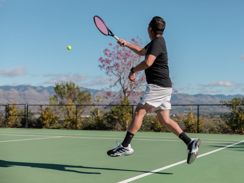 Image of a tennis player hitting a forehand wearing the adidas Barricade 13