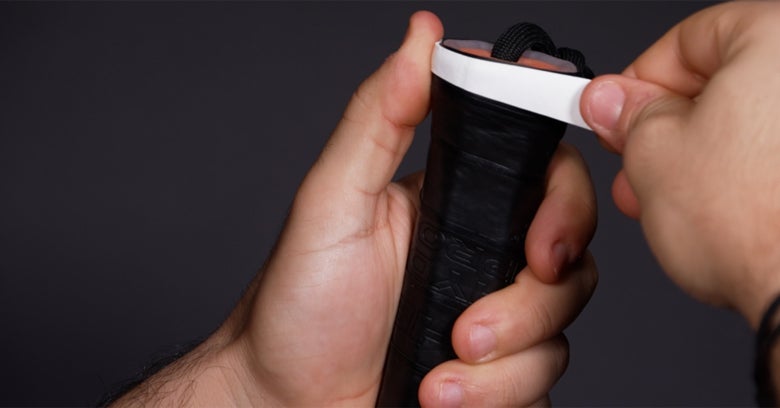 Applying the overgrip from the butt cap